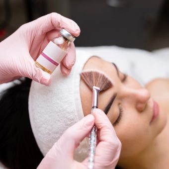 Esthetician performing chemical peel to client's face