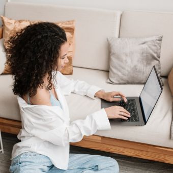 Woman typing on a laptop on the couch