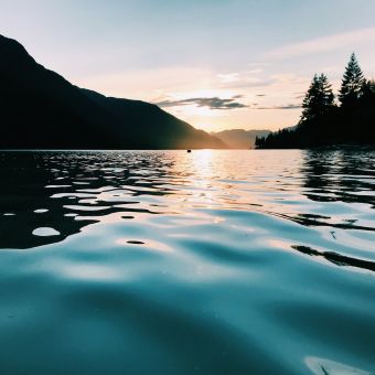 Sunset reflecting over Lake Superior water with trees in silhouette